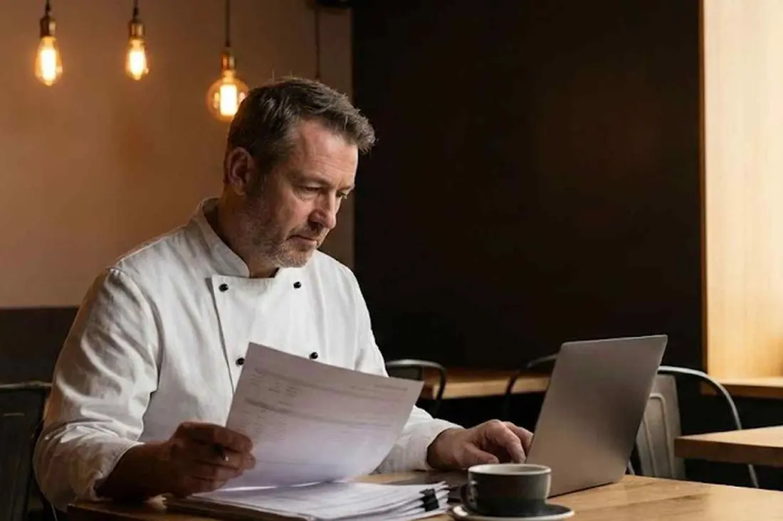 Restaurant owner reviewing business loan documents in their restaurant.